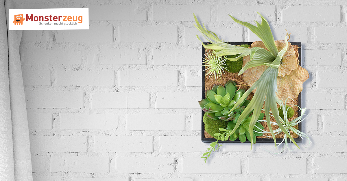 Vertikaler Garten für die Wand mit Deko-Pflanzen auf Sand